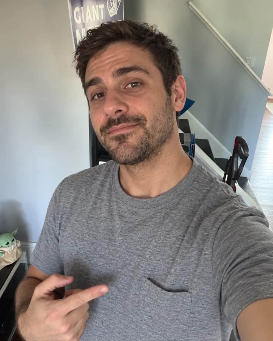 Chris's casual hallway selfie in a grey t-shirt