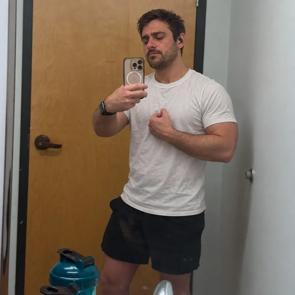 Chris's low-light mirror selfie in a white t-shirt